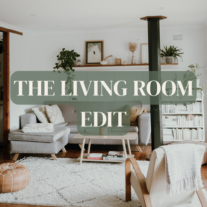 A styled living room interior with a gray sofa, light wood coffee table, white rug, shelving, plants, and a large overlaid text banner reading 'THE LIVING ROOM EDIT'.